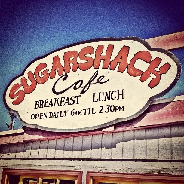 Close-up of the hand-painted Sugarshack Cafe sign with a warm vintage filter