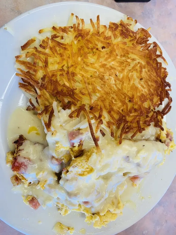 Scrambled eggs and ham smothered in country gravy with a side of hash browns