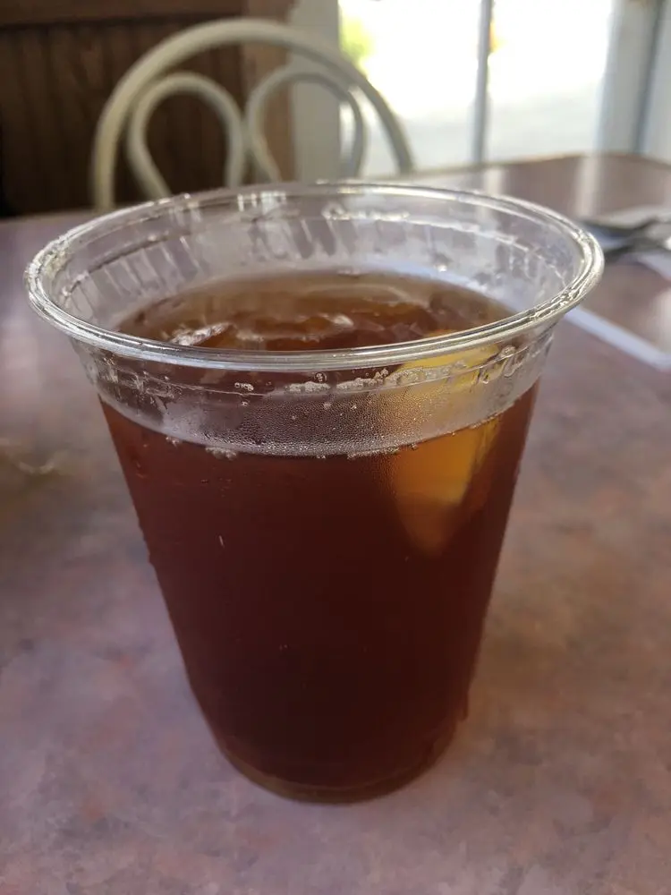 Chilled plastic cup of iced tea on a cafe table