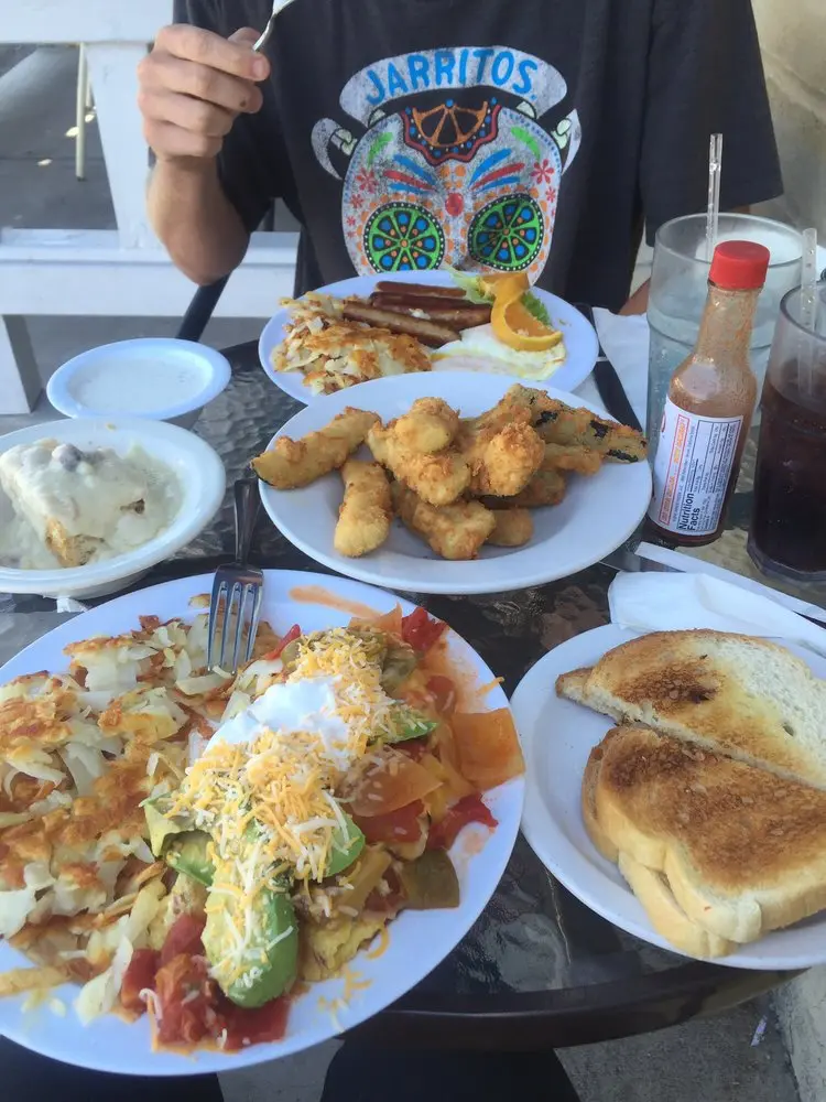 Abundant breakfast table spread with a loaded omelette, fried zucchini and toast